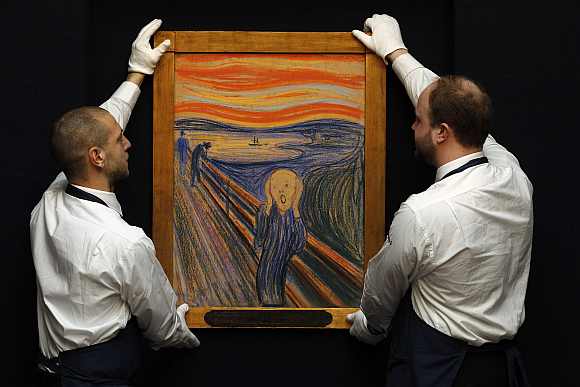 Sotheby's employees pose for a photograph with Edvard Munch's 'The Scream' at Sotheby's auction house in London