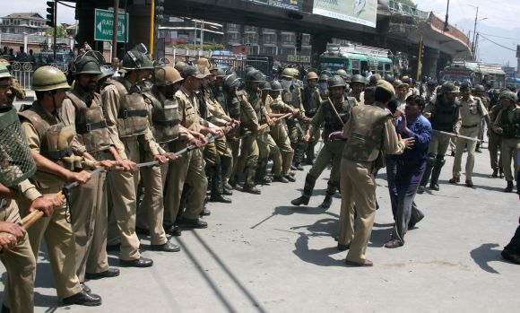 A striking protestor clashes with police in Srinagar on Wednesday