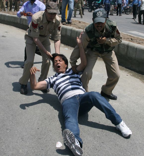 A protesting J&K government employee is removed by the security personnel in Srinagar as their strike reached second day on Wednesday