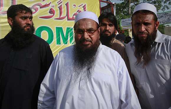 Hafiz Saeed, the head of Jamaat-ud-Dawa, gestures to the media as he arrives to attend a rally organised by the Defence Council of Pakistan in Lahore