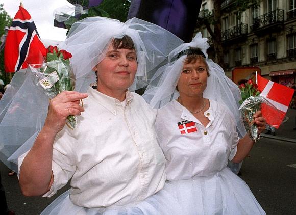 A Norwegian and Danish lesbian couple is dressed up as brides during a march with tens of thousands of homosexuals from all over Europe in their Europride festive parade  in Oslo