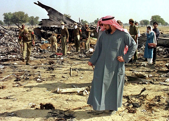 A relative of a Saudi Arabian victim of the mid-air collision, walks through wreckage of the Saudi Arabian jumbo jet outside the village of Charkhi Dadri