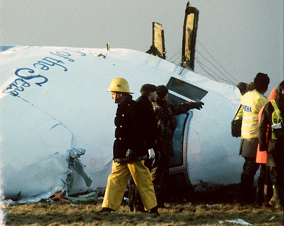Scottish rescue workers and crash investigators search the area around the cockpit of Pan Am flight 103 in a farmer's field east of Lockerbie Scotland