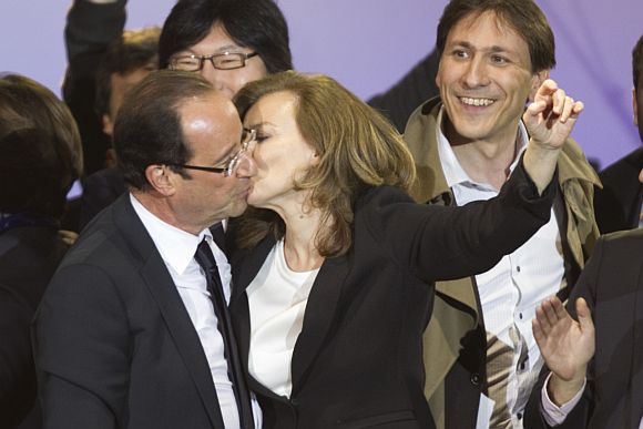 France's newly-elected President Francois Hollande (L) and his companion Valerie Trierweiler kiss as they celebrate