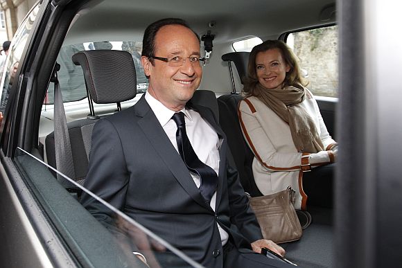 Francois Hollande (L), Socialist Party candidate for the 2012 French presidential election, and his companion Valerie Trierweiler sit in a car