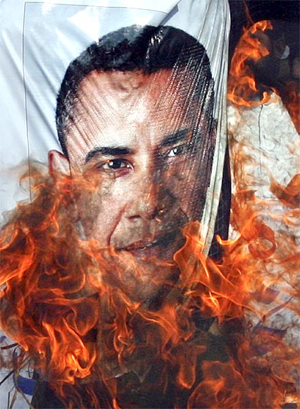 Supporters of the religious political party Sunni Tehreek set ablaze an effigy of US President Barack Obama