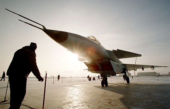 A man stands near a new multi-functional front-line fifth-generation fighter, code-named Project 1-42, at Zhukovsky flight and reseach institute outside Moscow