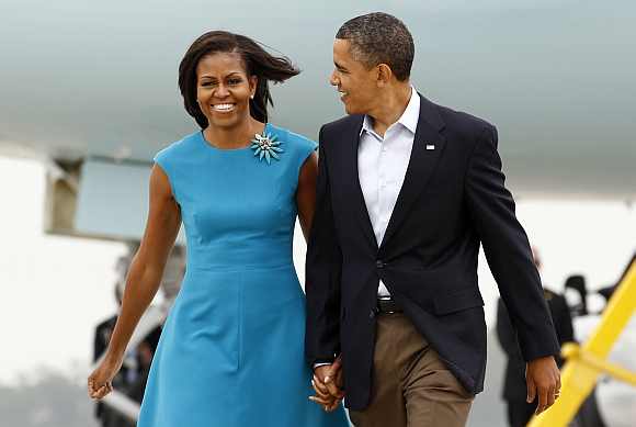 US President Barack Obama and first lady Michelle Obama walk from Air Force One