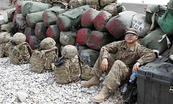 A US army soldier rests among luggage while waiting for a flight to go home after finishing his one year deployment in Afghanistan