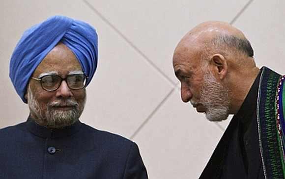 Afghan President Hamid Karzai speaks with Prime Minister Manmohan Singh