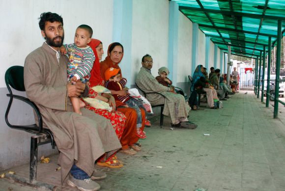Parents with their children can be seen waiting for doctors at the hospital