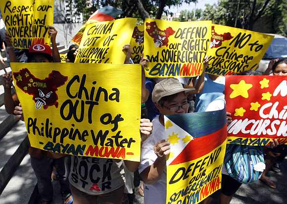 Activists hold placards in front of the Chinese consulate demanding the withdrawal of Chinese ships from the disputed Scarborough Shoal in the South China Sea during a protest in Manila's Makati financial district