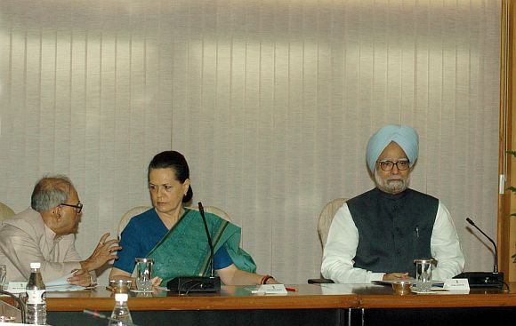 Finance Minister Pranab Mukherjee talks to UPA chairperson Sonia gandhi at the UPA leaders meeting. Also seen is Prime Minister Manmohan Singh