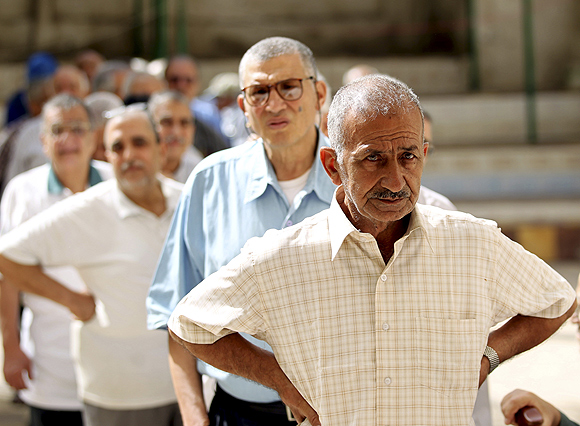 Voters wait in line to cast their votes at a polling station in Alexandria