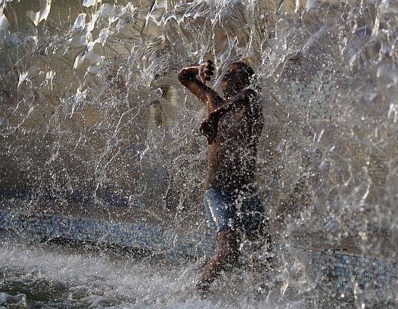 A boy dances in a water fountain in Hyderabad