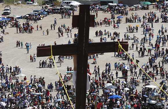 Worshippers stand underneath a hill during a re-enactment of the crucifixion of Jesus Christ on a hill on Good Friday in Ciudad Juarez
