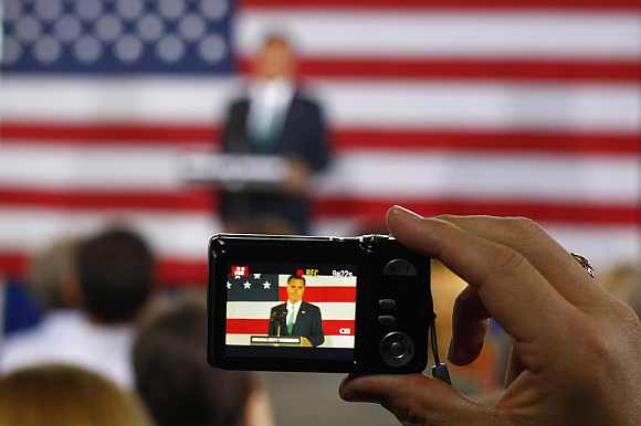 A supporter uses a camera to capture a video of Romney in Charlotte, North Carolina