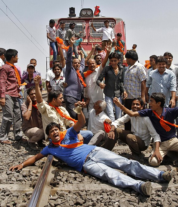 Supporters of the Bharatiya Janata Party shout slogans while blocking a railway track during a protest against a hike in petrol prices in Ahmedabad