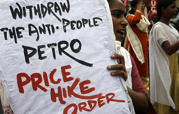 An activist from Socialist Unity Centre of India holds a placard as she shouts slogans during a protest against the hike in fuel prices, in Kolkata