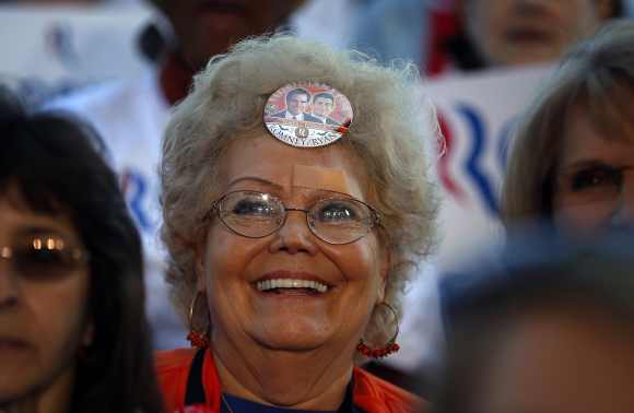 An audience member with a campaign button in her hair waits for Republican presidential nominee Mitt Romney at a campaign rally in Tampa, Florida