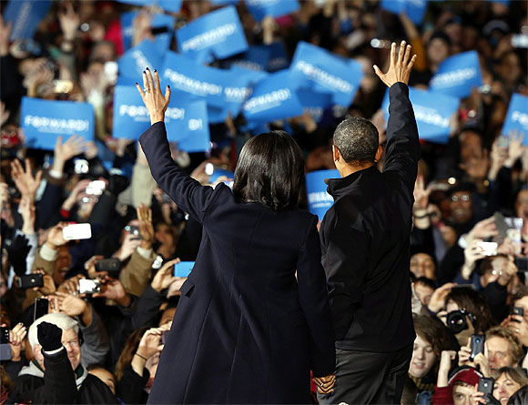 US President Barack Obama and First Lady Michelle Obama wave to their supporters