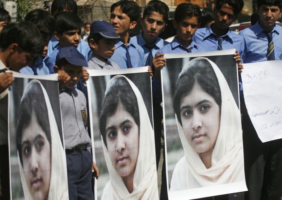 Students hold pictures of Malala Yousufzai to show their solidarity at a school in Karachi