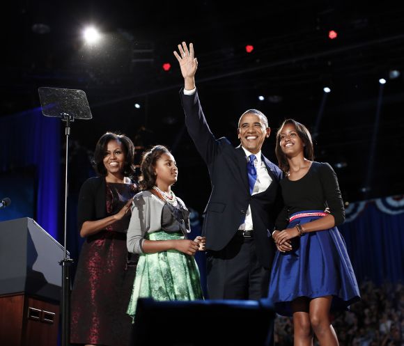 US President Barack Obama gathers with his wife Michelle Obama and daughters Sasha and Malia during his election night victory rally in Chicago