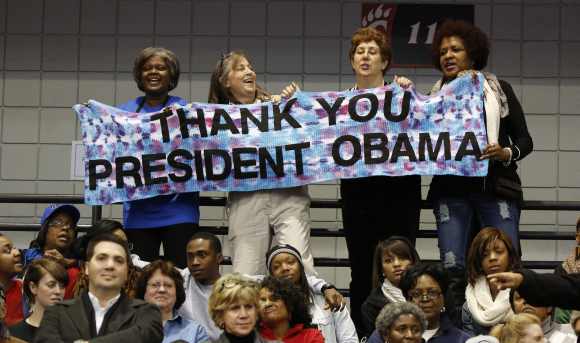 Supporters hold a sign as Obama speaks at a campaign event at Fifth Third Arena at the University of Cincinnati