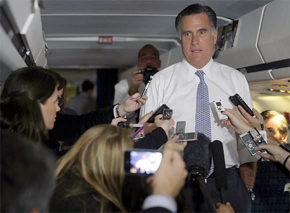Republican presidential nominee Mitt Romney talks to reporters on his campaign plane