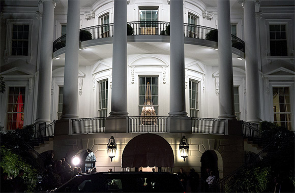 US President Barack Obama (silhouetted in car window) and his family return to the White House