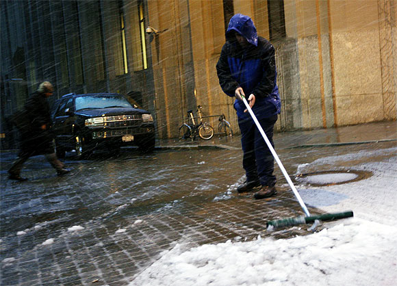 worker clears snow outside the New York Stock Exchange in New York