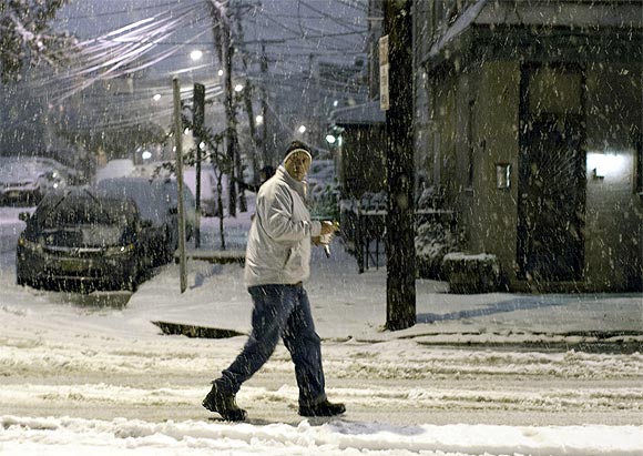 A man walks in the snow during the nor'easter, also known as a northeaster storm, in Jersey City, New Jersey