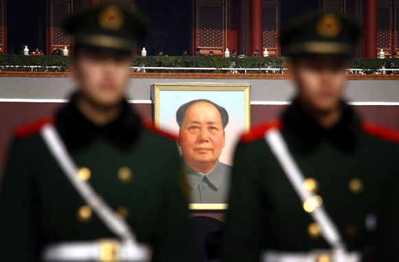 Paramilitary policemen stand guard in front of the giant portrait of former Chinese chairman Mao Zedong at Beijing's Tiananmen Square, as security is tightened around the square and the adjoining Great Hall of the People