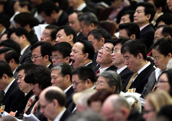 A delegate yawns during the opening ceremony of the National People's Congress at the Great Hall of the People in Beijing