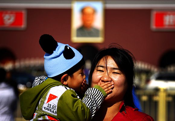 A boy and his mother pose for a photograph at Beijing's Tiananmen Square