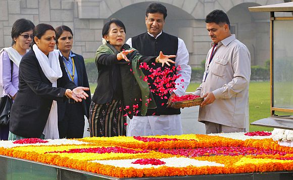 Aung San Suu Kyi scatters rose petals at the Mahatma Gandhi memorial at Rajghat in New Delhi on Wednesday