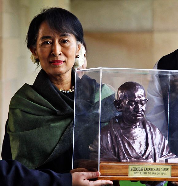 Suu Kyi holds a bust of Mahatma Gandhi at his memorial at Rajghat in New Delhi