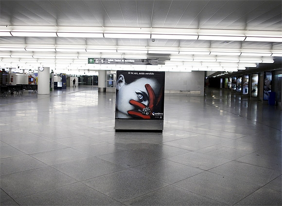 An advertising board is seen at a nearly empty arrival hall at Atocha rail station