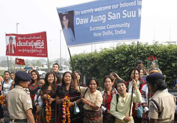 Supporters Suu Kyi, hold banners to welcome her at the Indira Gandhi international airport in New Delhi