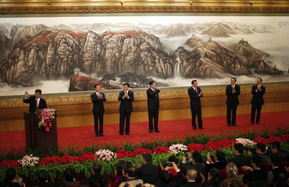 Newly-elected General Secretary of the Central Committee of the Communist Party of China Xi Jinping waves after giving a speech as he meets with the press with other new Politburo Standing Committee members