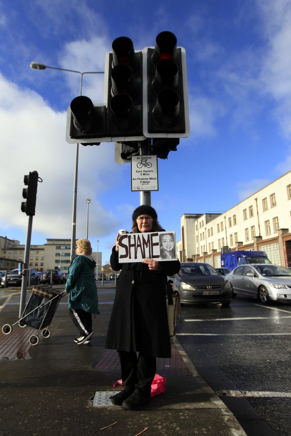 Mary Phelan holds a picture of Savita Halappanavar in protest outside University Hospital Galway in Galway, Ireland. Thousands held a candle-lit vigil outside parliament on Wednesday after the news broke of death of Savita Halappanavar, 31, from septicaemia days after miscarrying 17 weeks into her pregnancy and her husband said she had been denied an abortion.