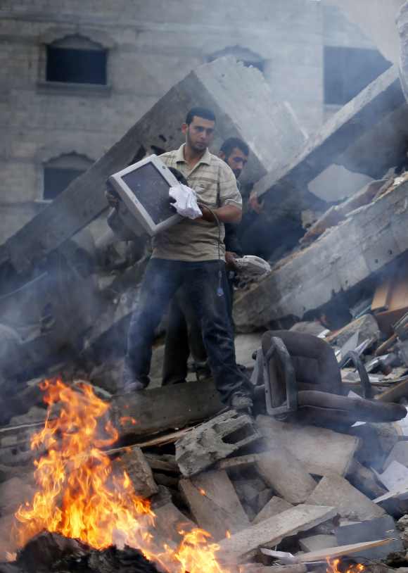Palestinians remove items from the destroyed office building of Hamas Prime Minister Ismail Haniyeh
