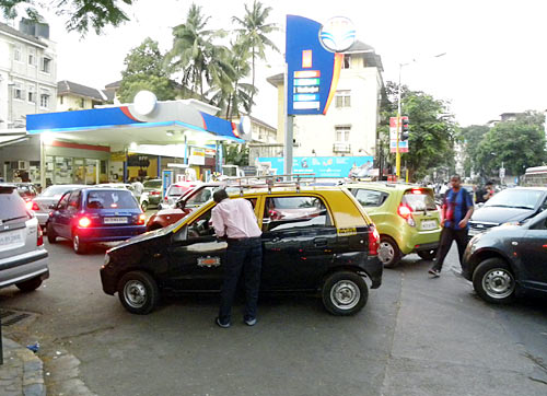 Vehicles pile up at a petrol pump to stock up
