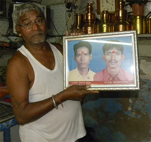 Waghela, with a picture of his sons. Thakur, right, who was killed in the terror attack, while his older son died of an illness in 2004