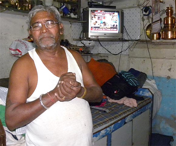 Budhabhai Jethabhai Waghela, who lost his son in 26/11 attacks, watches the news of Kasab's execution