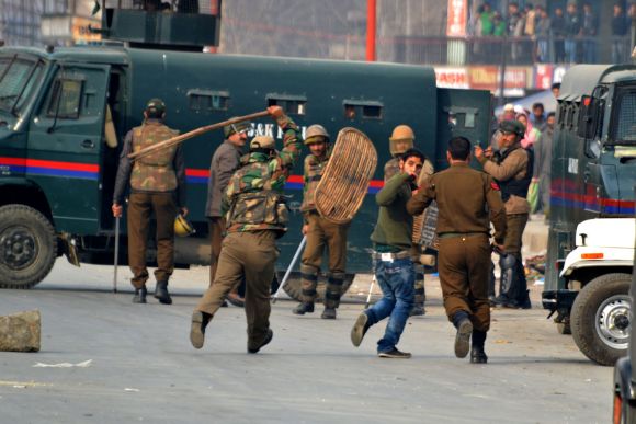 Police personnel lathicharge a protestor in Srinagar on Friday