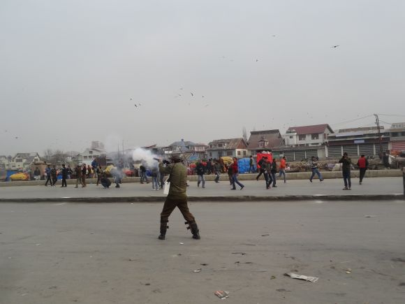Police fires a tear gas shell to disperse protestors in Srinagar on Friday