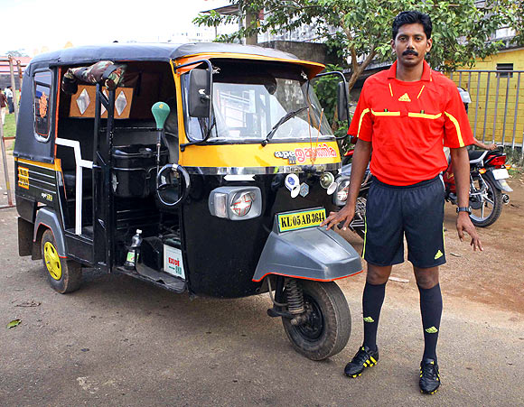 Santhosh Kumar in his referee attire with his autorickshaw