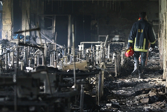 A firefighter inspects a garment factory after a fire in Savar