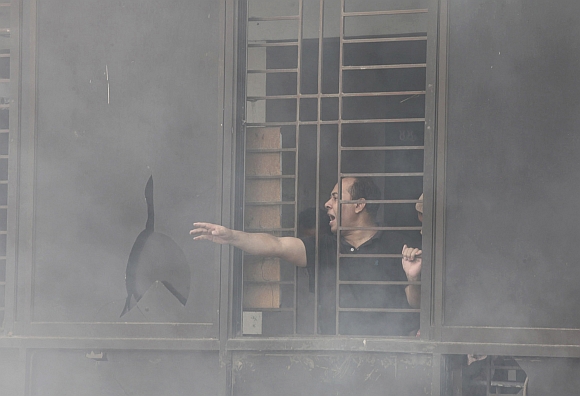 A worker calls for help as he is trapped in an 11-storey garment factory building where a fire had broken out, in the suburb of Uttara in Dhaka